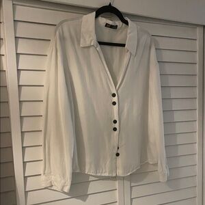 White blouse with long sleeves. Button down front with collar